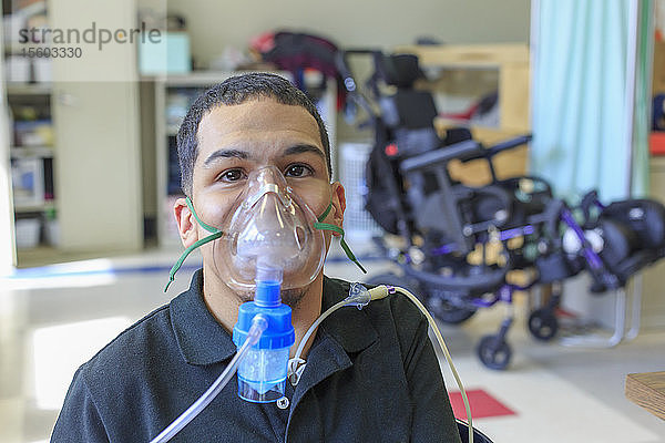 Junge mit spastischer Quadriplegie und Zerebralparese lernt in der Schule und benutzt seine medizinische Atemmaske
