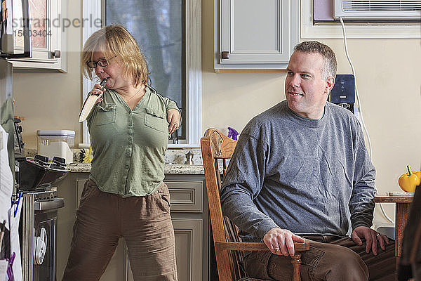 Frau mit TAR-Syndrom  die mit ihrem Mann in der Küche ein Messer in die Hand nimmt