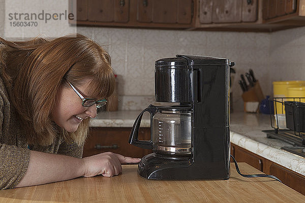 Eine blinde Frau kocht Kaffee in ihrer Küche