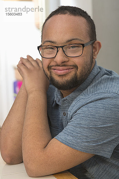 Porträt eines glücklichen afroamerikanischen Mannes mit Down-Syndrom zu Hause