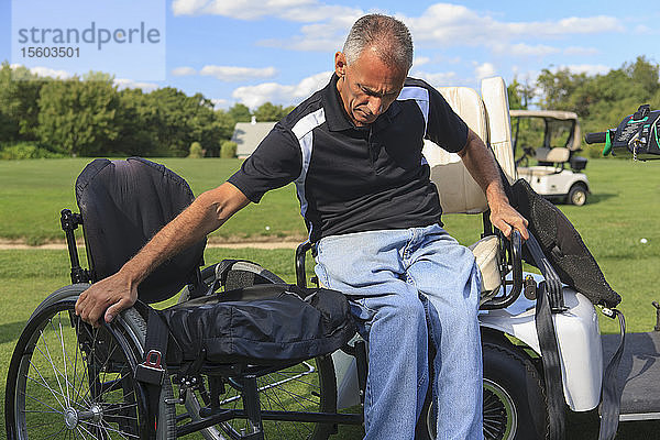 Ein Mann mit einer Rückenmarksverletzung in einem adaptiven Golfwagen steigt in seinen Rollstuhl