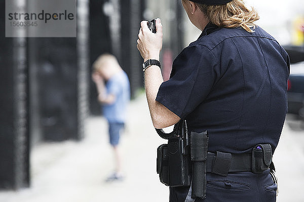 Eine Polizeibeamtin spricht in ein Handmikrofon.