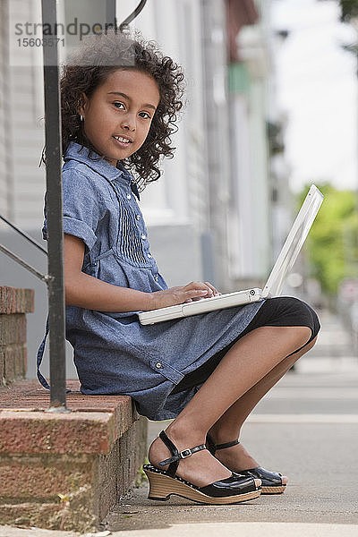 Porträt eines hispanischen Mädchens  das einen Laptop benutzt