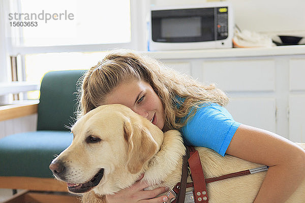 Frau mit Sehbehinderung umarmt ihren Diensthund