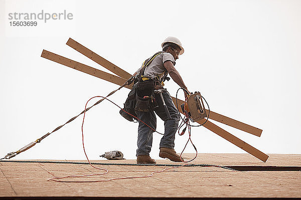 Zimmermann mit Brettern und einer Kreissäge auf einer Baustelle