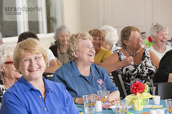 Lachende Seniorinnen bei einem Mittagessen