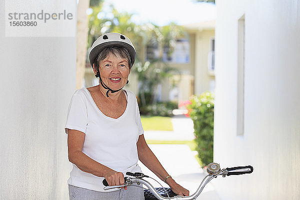 Ältere Frau stehend mit einem Fahrrad