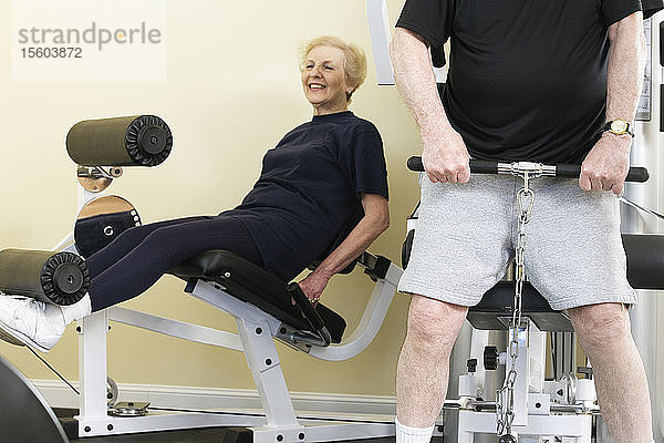 Ein älteres Paar trainiert im Fitnessstudio.