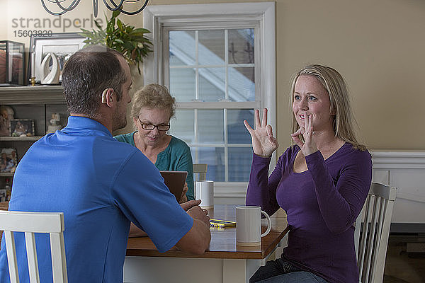 Drei Personen in einer Besprechung und zwei  die sich in ASL über Perfect zu Hause unterhalten