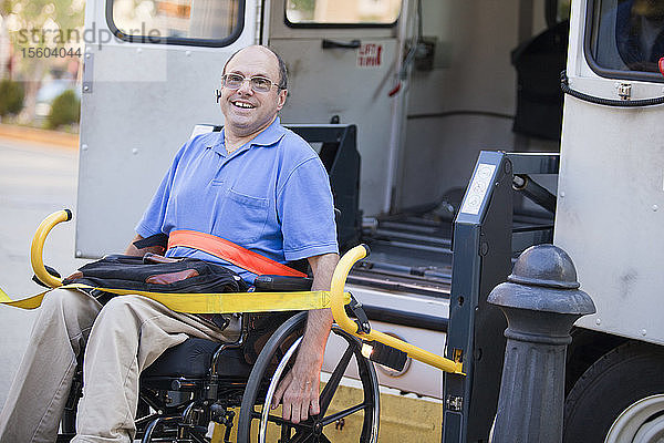 Mann mit Friedreich-Ataxie im Rollstuhl beim Einstieg in ein öffentliches Verkehrsmittel