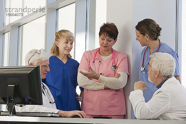 Krankenschwestern und Ärzte besprechen Patienten am Computer. Arzt hat Muskeldystrophie