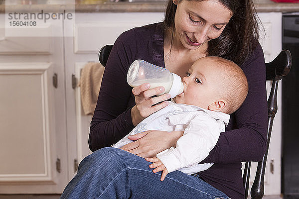 Mutter füttert ihren Sohn mit der Flasche