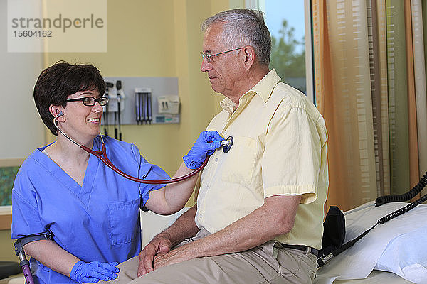 Krankenschwester mit Cerebralparese überprüft das Herz eines Patienten in einer Klinik