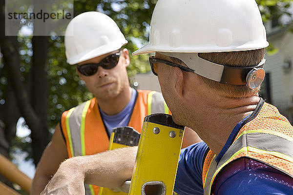 Zwei Arbeiter unterhalten sich auf einer Baustelle