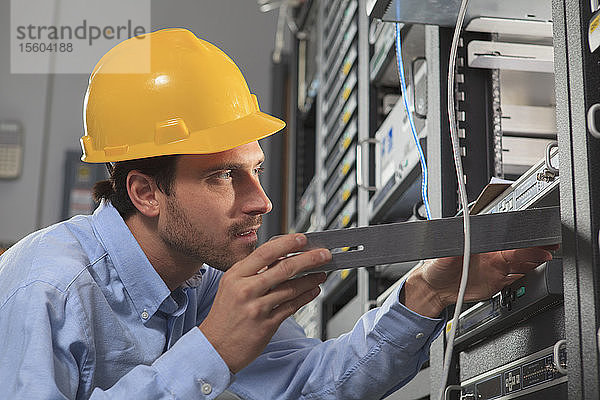 Netzwerktechniker bei der Installation von Geräteeinschüben im Rack