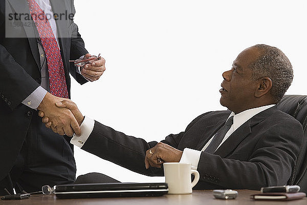 Zwei Geschäftsleute beim Händeschütteln in einem Büro