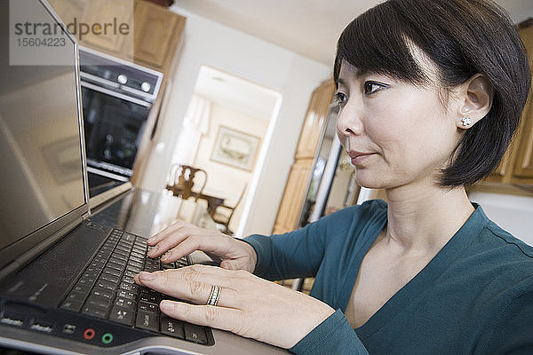 Seitenprofil einer Frau im mittleren Erwachsenenalter  die einen Laptop benutzt