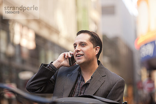 Geschäftsmann  der mit einem Mobiltelefon spricht