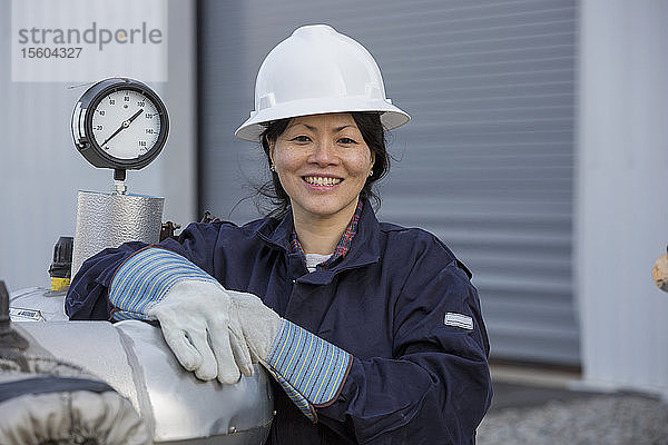 Porträt einer Energietechnikerin mit Drucksensor im Kraftwerk