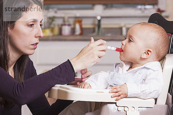 Mutter gibt ihrem Sohn Medizin