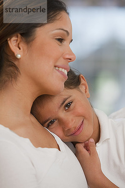 Hispanische Frau  die ihre Tochter umarmt