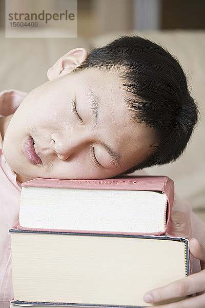 Nahaufnahme eines schlafenden Teenagers auf einem Bücherstapel