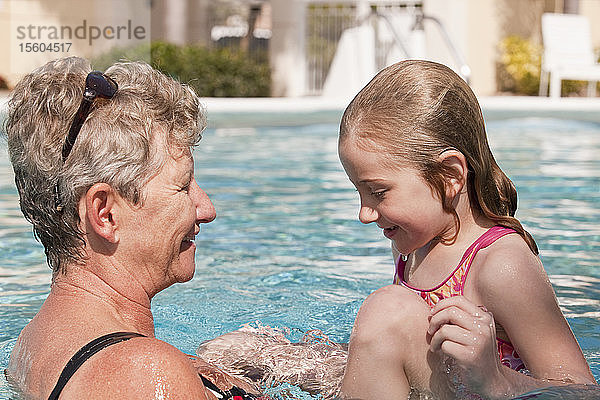 Frau und ihre Enkelin vergnügen sich in einem Schwimmbad