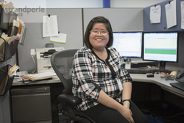 Porträt einer glücklichen asiatischen Frau mit einer Lernbehinderung  die im Büro lächelt