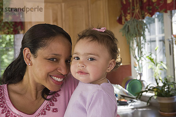 Hispanische Frau lächelt mit ihrer Tochter