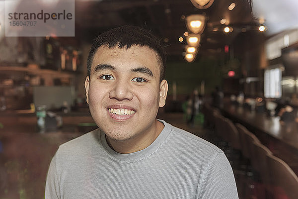 Junger Mann mit Autismus arbeitet in einem Restaurant