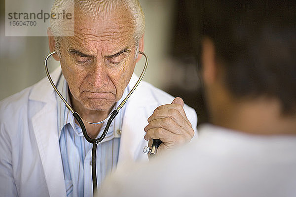 Blick auf einen Arzt  der einen Patienten untersucht.