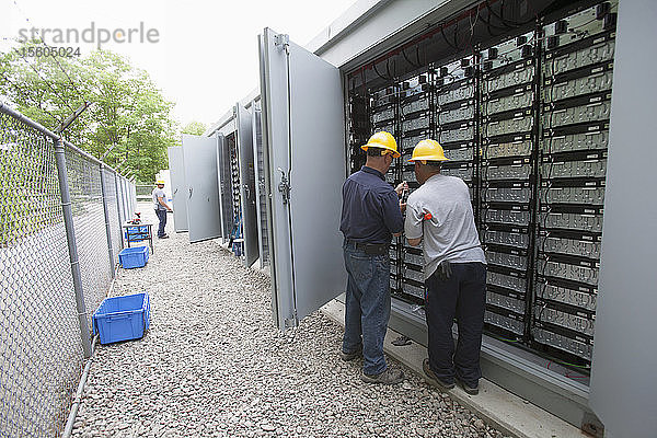 Ingenieur  der Energiespeicherbatterien zur Notstromversorgung eines Kraftwerks anschließt