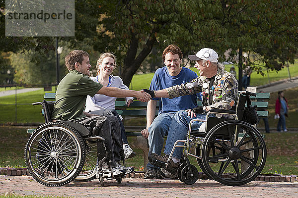 Veteranen treffen Freunde und schütteln sich im Park die Hände