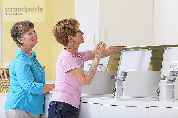 Ältere Frauen suchen im Schrank der Waschküche