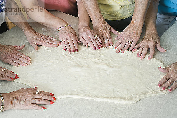 Mittelschnittansicht von Frauen beim Pizzabacken