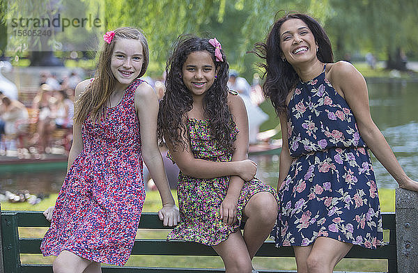 Porträt einer glücklichen hispanischen Mutter und zwei Teenager-Töchter im Park