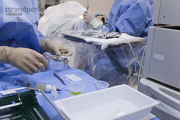 Chirurgische Technologin  die für den Arzt während der Operation die Linse in den Einsetzer setzt