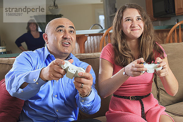 Vater und Tochter spielen Videospiele auf ihrem Fernsehbildschirm