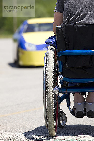 Person im Rollstuhl mit Blick auf den Rennwagen  Rückansicht