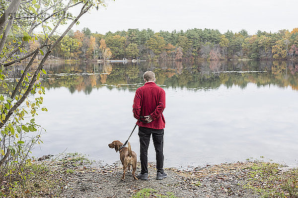 Mann mit Angststörung und sein Therapiehund an einem See