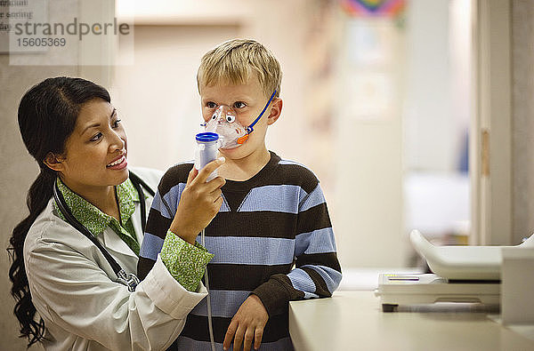 Arzt setzt einem kleinen Jungen eine Sauerstoffmaske auf