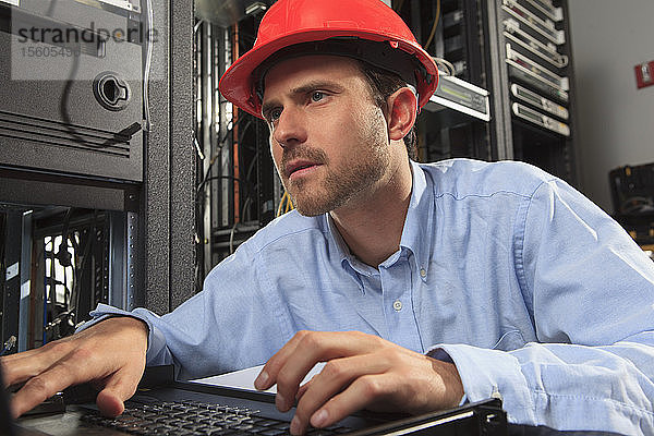 Netzwerktechniker prüft die Systemkonfiguration an der Tastatur