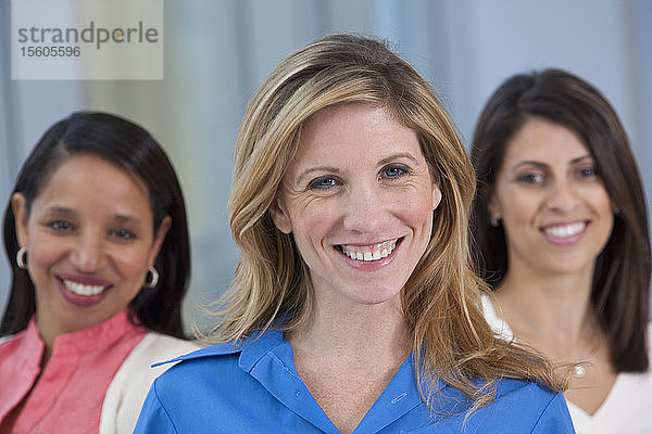 Porträt einer lächelnden Frau mit ihren Freunden im Hintergrund