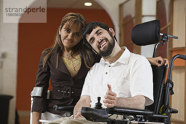 Porträt eines Mannes mit zerebraler Lähmung und einer lächelnden Frau