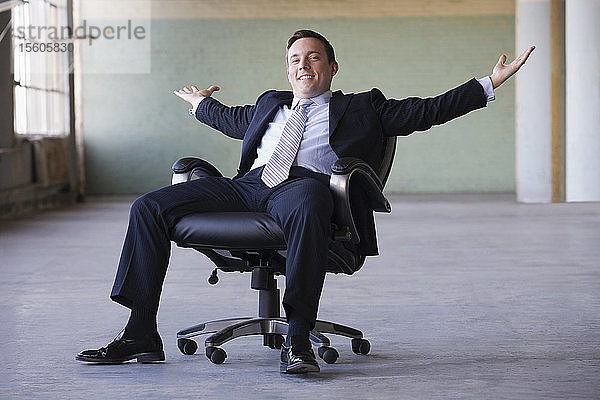 Porträt eines lächelnden Geschäftsmannes mit ausgestrecktem Arm