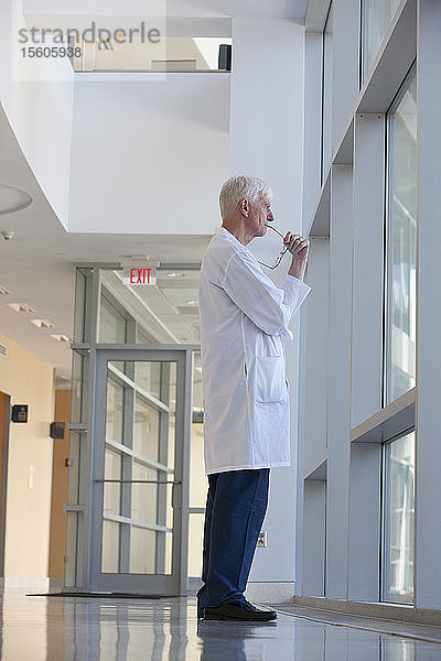 Gedankenverlorener Arzt am Krankenhausfenster