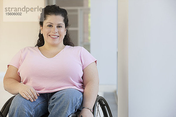 Frau mit Spina Bifida sitzt im Rollstuhl und lächelt