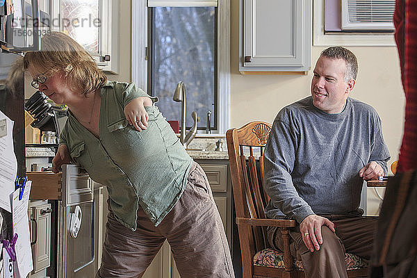 Frau mit TAR-Syndrom benutzt zusammen mit ihrem Mann eine Küchenschublade