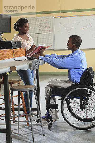 Ingenieurstudenten in einem Elektronik-Klassenzimmer  einer im Rollstuhl  bei der Arbeit mit einem PC auf einem Labortisch