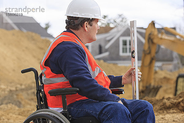 Bauingenieur mit Querschnittslähmung hält auf der Baustelle die Stellung